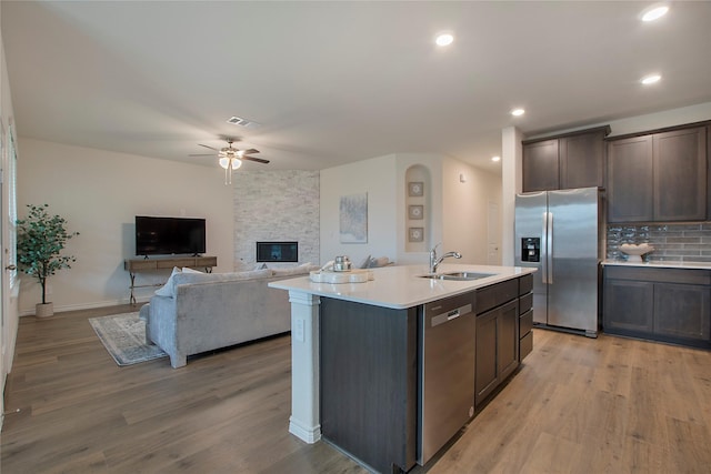 10337 Geode St, Aubrey, TX 76227 - kitchen featuring light wood-style flooring, a ceiling fan, a sink, stainless steel appliances, and light countertops