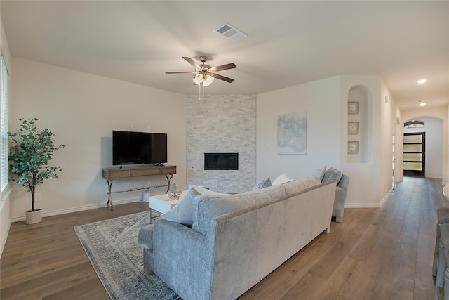 10337 Geode St, Aubrey, TX 76227 - living room with wood finished floors, visible vents, a fireplace, arched walkways, and a ceiling fan