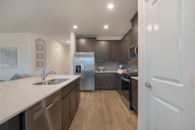 10337 Geode St, Aubrey, TX 76227 - kitchen featuring a sink, stainless steel appliances, light countertops, dark brown cabinets, and light wood-style floors