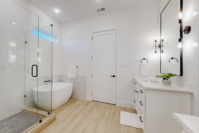 3791 Evergreen Ln, Caddo Mills, TX 75135 - bathroom featuring wood finished floors, vanity, visible vents, a shower stall, and a freestanding bath