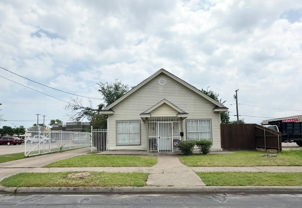 bungalow featuring a gate, fence, and concrete driveway