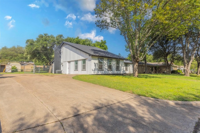337 Travis Ln, Hewitt, TX 76643 - rear view of house with a yard, driveway, board and batten siding, fence, and central AC