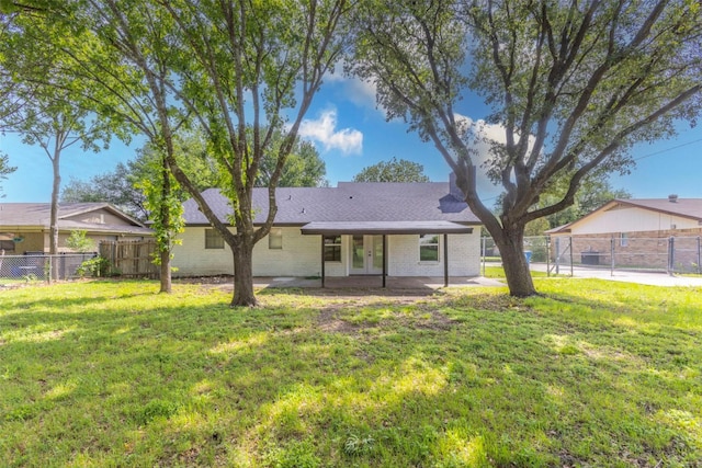337 Travis Ln, Hewitt, TX 76643 - back of property with fence, french doors, brick siding, and a lawn
