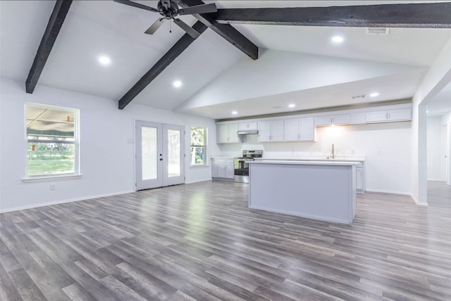 337 Travis Ln, Hewitt, TX 76643 - kitchen featuring stainless steel range with electric stovetop, open floor plan, a center island with sink, white cabinetry, and beamed ceiling