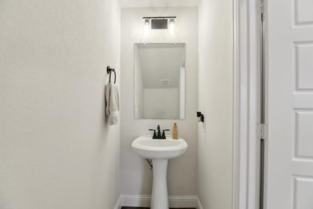 bathroom with baseboards and a sink