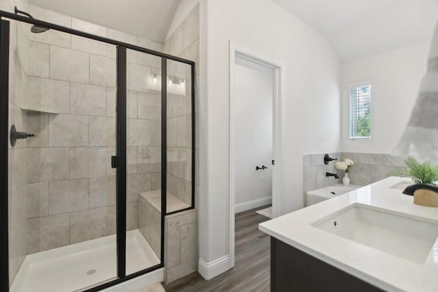 full bath with wood finished floors, a sink, baseboards, a shower stall, and vaulted ceiling