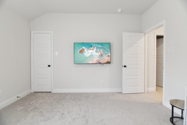unfurnished bedroom featuring baseboards, carpet floors, and vaulted ceiling