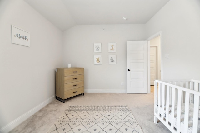bedroom with light colored carpet, lofted ceiling, and baseboards