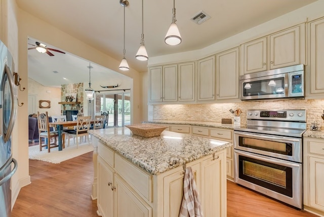 kitchen featuring a ceiling fan, visible vents, cream cabinetry, decorative backsplash, and stainless steel appliances