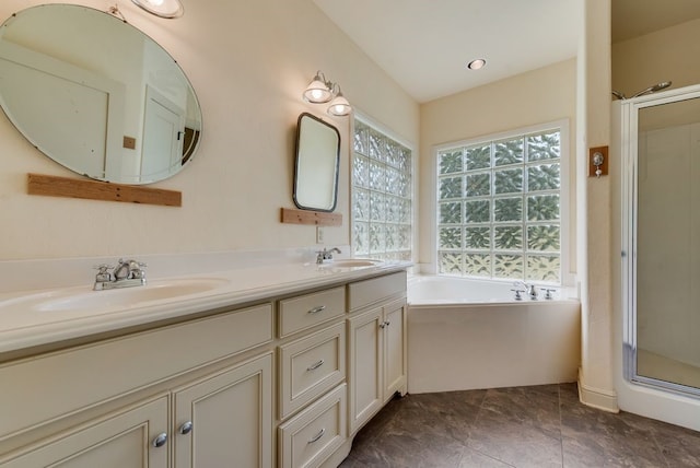 full bathroom featuring a sink, double vanity, a stall shower, and a garden tub