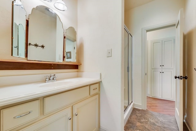 full bathroom with vanity, wood finished floors, and a stall shower