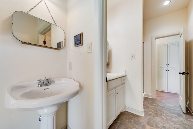 full bathroom with baseboards, a shower stall, and a sink