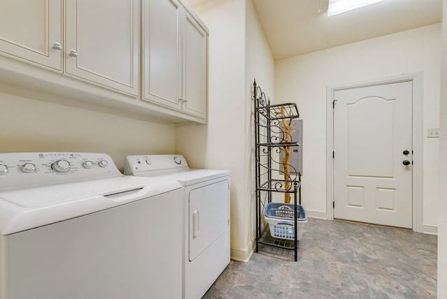 laundry area with cabinet space, separate washer and dryer, and stone finish flooring