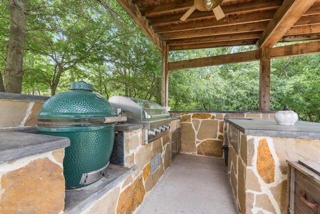 view of patio / terrace featuring a ceiling fan, area for grilling, and exterior kitchen