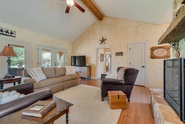 living area featuring french doors, light wood-style flooring, a ceiling fan, high vaulted ceiling, and beam ceiling