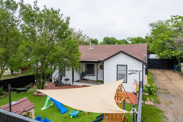 1100 Hillburn Dr, Dallas, TX 75217 - rear view of house with a shingled roof, fence, and a lawn