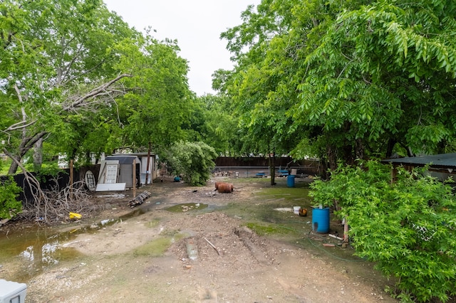 1100 Hillburn Dr, Dallas, TX 75217 - view of yard featuring fence, a storage shed, and an outbuilding