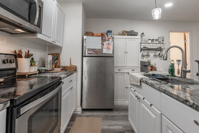 1100 Hillburn Dr, Dallas, TX 75217 - kitchen featuring a sink, stainless steel appliances, dark stone countertops, dark wood-style flooring, and white cabinets