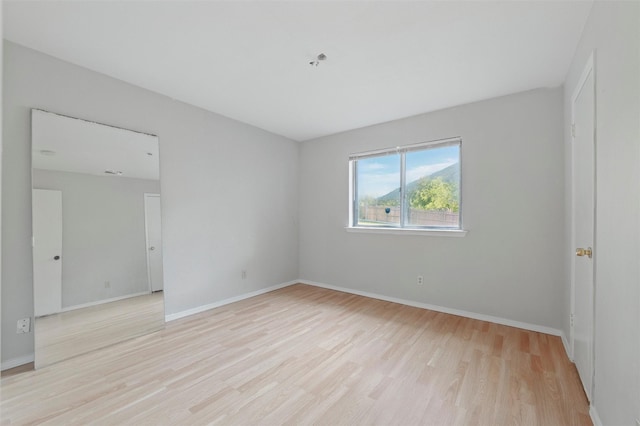 empty room with light wood-type flooring and baseboards