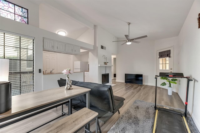 2964 Harbinger Ln, Dallas, TX 75287 - living room with a ceiling fan, high vaulted ceiling, a fireplace with flush hearth, light wood-style floors, and baseboards