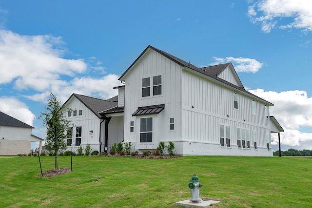 5614 Gaelic Dr, Celina, TX 75009 - back of property with board and batten siding, a standing seam roof, a yard, and a metal roof