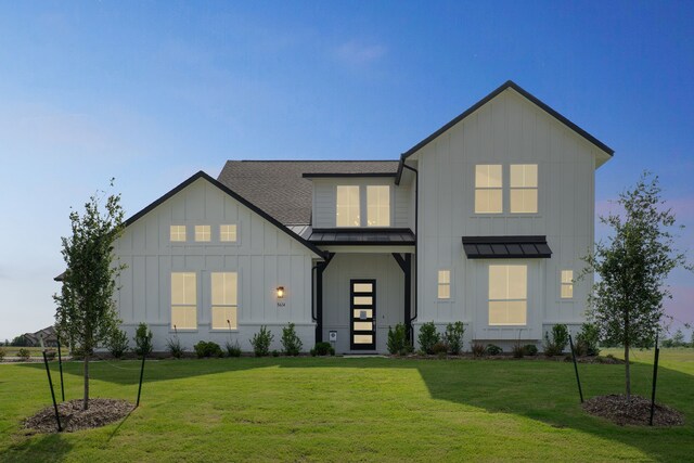 5614 Gaelic Dr, Celina, TX 75009 - view of front of home with board and batten siding, a standing seam roof, a front lawn, and a shingled roof