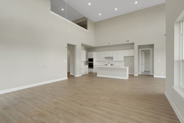 5614 Gaelic Dr, Celina, TX 75009 - unfurnished living room featuring a high ceiling, light wood-style floors, and recessed lighting