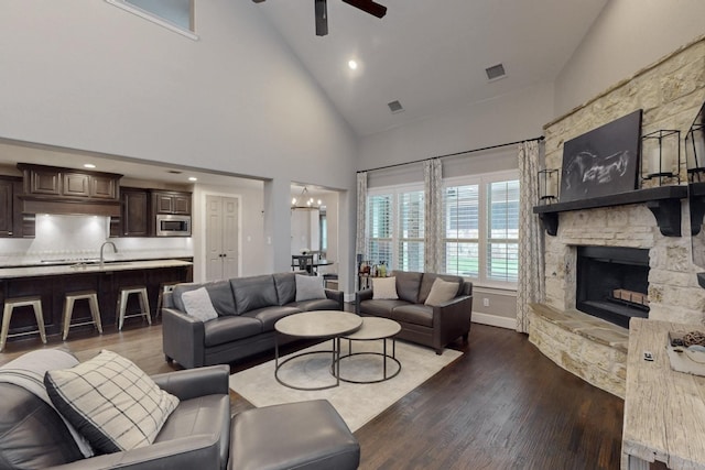 6404 Spring Wagon Dr, Mckinney, TX 75071 - living room with a ceiling fan, high vaulted ceiling, a fireplace, dark wood-style floors, and a chandelier