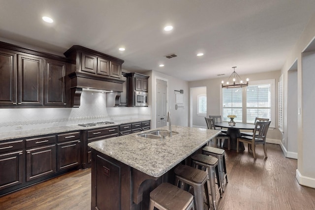 6404 Spring Wagon Dr, Mckinney, TX 75071 - kitchen with a sink, stainless steel appliances, baseboards, decorative backsplash, and a kitchen breakfast bar