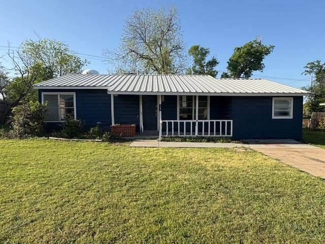 single story home featuring covered porch, metal roof, and a front yard