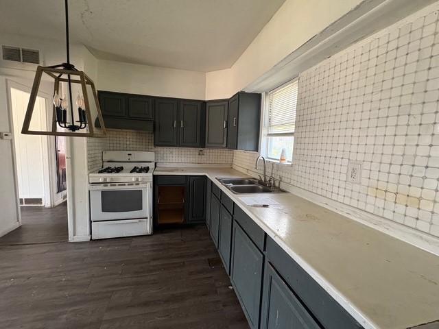 kitchen featuring a sink, tasteful backsplash, visible vents, white gas range oven, and light countertops