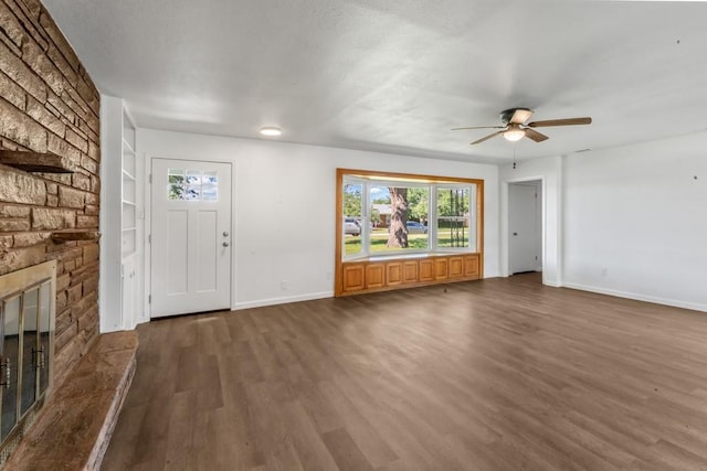 2349 Cooke St, Abilene, TX 79605 - unfurnished living room with dark wood-type flooring, a ceiling fan, baseboards, and a fireplace