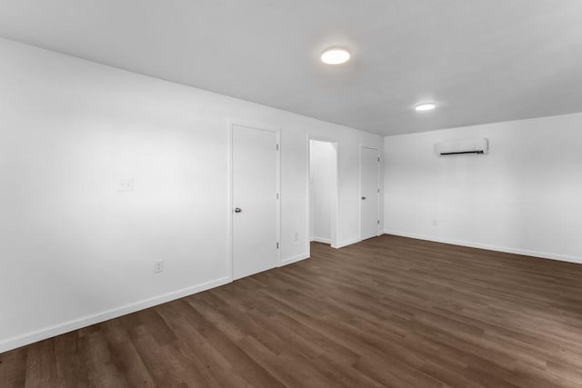 2349 Cooke St, Abilene, TX 79605 - empty room featuring a wall mounted AC, dark wood-type flooring, and baseboards