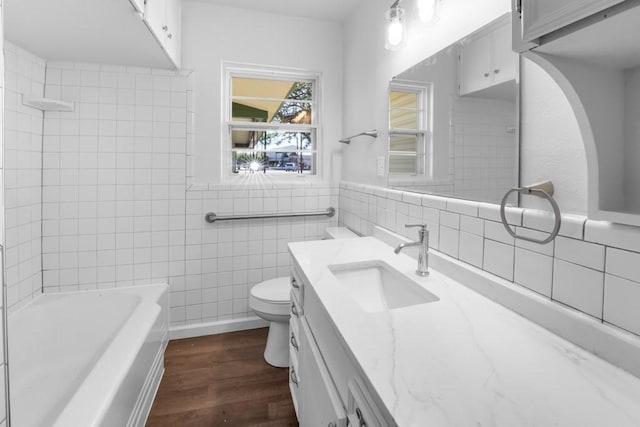 2349 Cooke St, Abilene, TX 79605 - full bathroom with tile walls, wood finished floors, toilet, and vanity