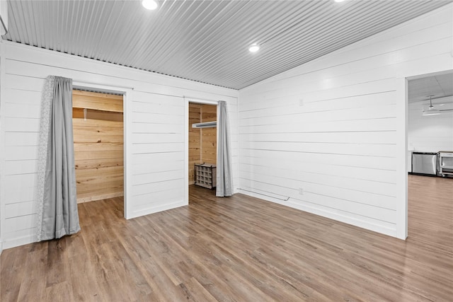2230 Farm Road 79, Paris, TX 75460 - unfurnished bedroom with wood walls, wood finished floors, lofted ceiling, and recessed lighting