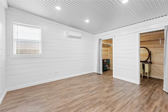 2230 Farm Road 79, Paris, TX 75460 - unfurnished bedroom featuring a walk in closet, wood walls, and a wall unit AC
