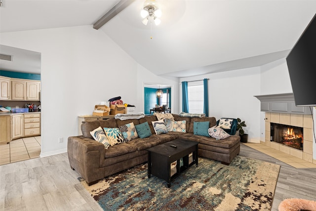 101 Remington Trl, Longview, TX 75604 - living area featuring light wood finished floors, beamed ceiling, a tiled fireplace, and ceiling fan
