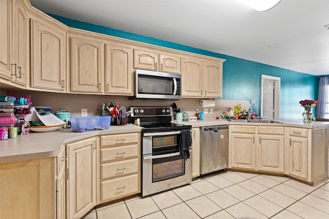 101 Remington Trl, Longview, TX 75604 - kitchen featuring a peninsula, light countertops, stainless steel appliances, and light brown cabinets