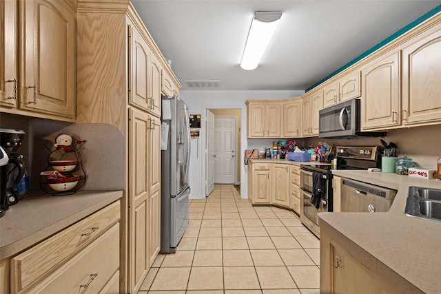 101 Remington Trl, Longview, TX 75604 - kitchen featuring visible vents, light countertops, light tile patterned floors, light brown cabinets, and appliances with stainless steel finishes