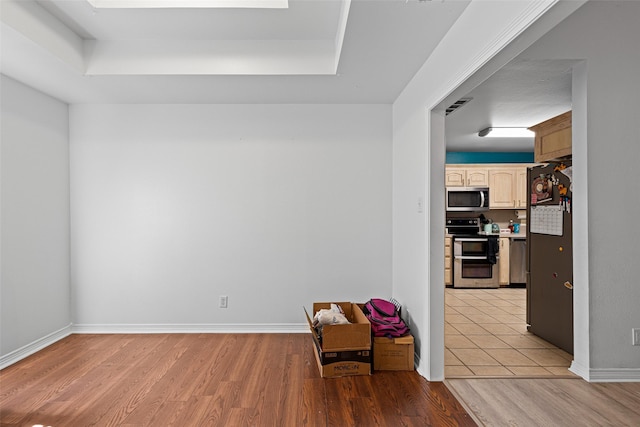 101 Remington Trl, Longview, TX 75604 - unfurnished room with baseboards, light wood-style flooring, and a raised ceiling