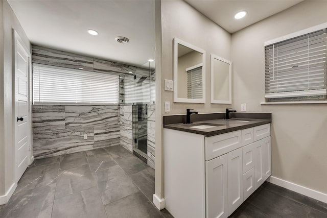 bathroom with a shower stall, double vanity, marble look tiles, recessed lighting, and baseboards