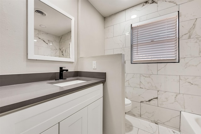 full bathroom featuring marble finish flooring, toilet, and vanity