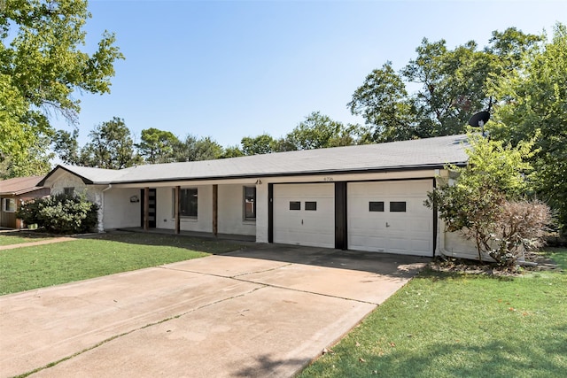 ranch-style home featuring an attached garage, a front lawn, and concrete driveway