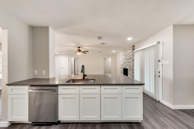 kitchen with dishwasher, a sink, dark countertops, white cabinets, and a ceiling fan