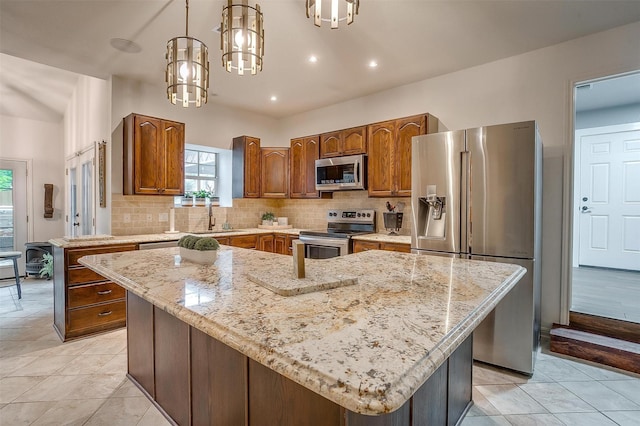 kitchen featuring stainless steel appliances, tasteful backsplash, light stone countertops, and a sink