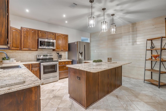 kitchen featuring a sink, stainless steel appliances, visible vents, wooden walls, and tasteful backsplash
