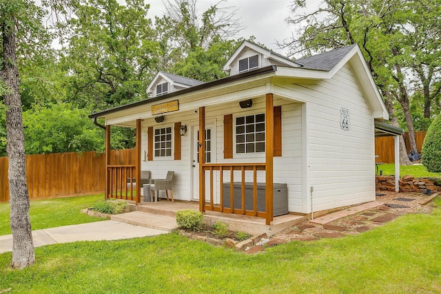 view of outdoor structure with a porch and fence