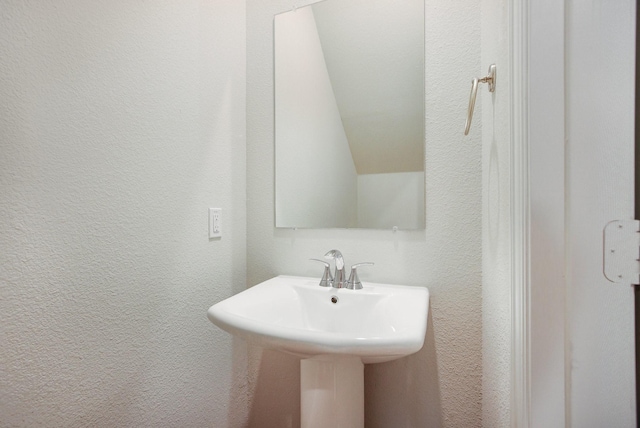 627 Rain Barrel Pl, Weston, TX 75009 - bathroom featuring lofted ceiling, a sink, and a textured wall