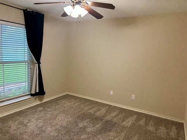 carpeted empty room featuring baseboards and a ceiling fan