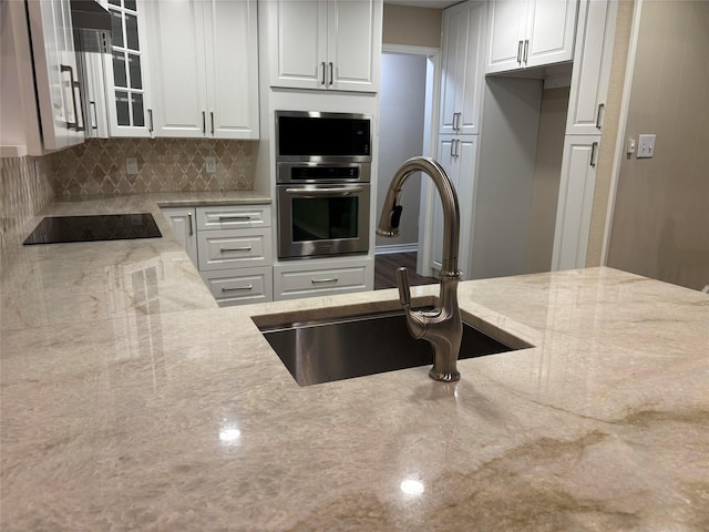 kitchen with white cabinets, glass insert cabinets, stainless steel appliances, and a sink